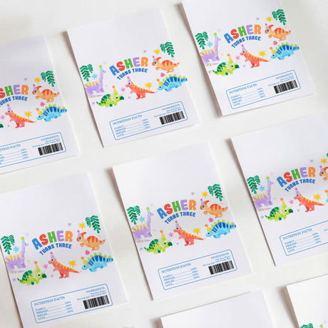 White printed chocolate birthday wrappers with colorful dinosaur design and Asher text