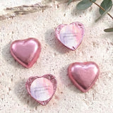 Foil-covered chocolate heart in pink with round white name label and foil edges