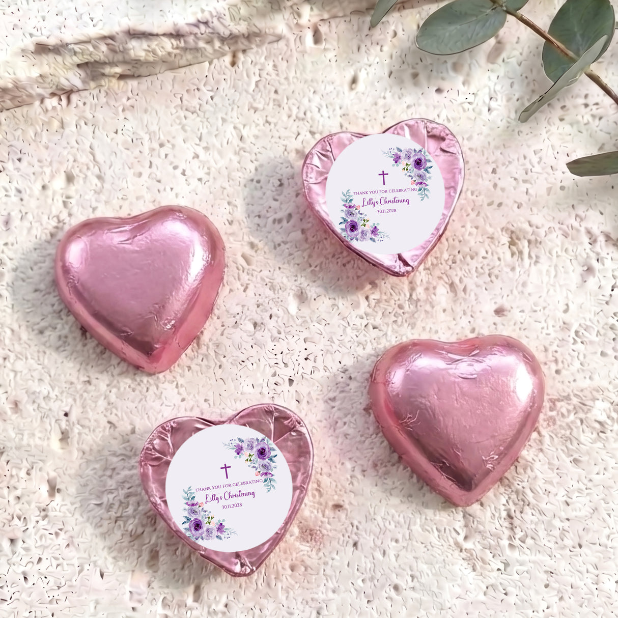 Pink foil-covered chocolate heart with personalized floral christening label, heart shape