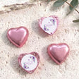 Foil-covered chocolate hearts, pink with purple floral confirmation design, heart-shaped