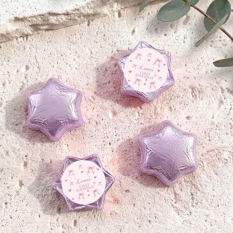Foil-covered chocolate stars in lavender/purple, with “Luna’s First Birthday” insert