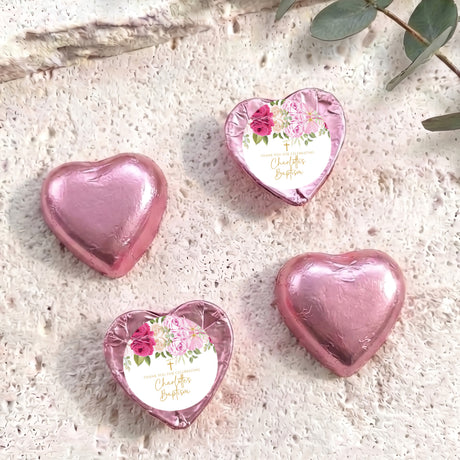 Heart-shaped foil-covered chocolate hearts in pink tones, with floral center labels
