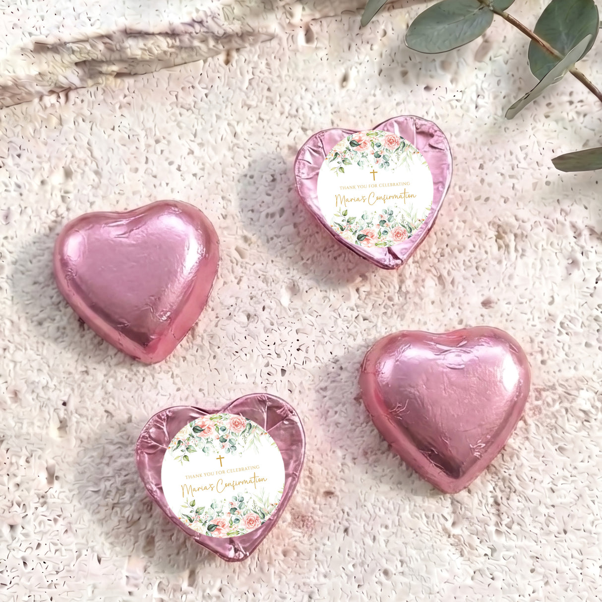 Pink foil-covered confirmation chocolate hearts, one heart shows floral message label