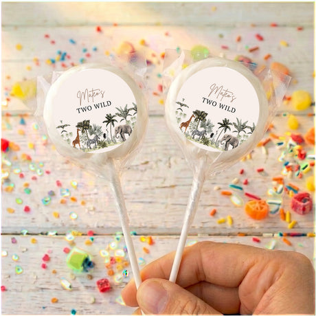 Personalized lollipops with jungle labels and clear wrappers, held in hand