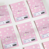 Pink DIY chocolate wrappers with white daisy pattern and 'MILLIE' text, 'turn one'.