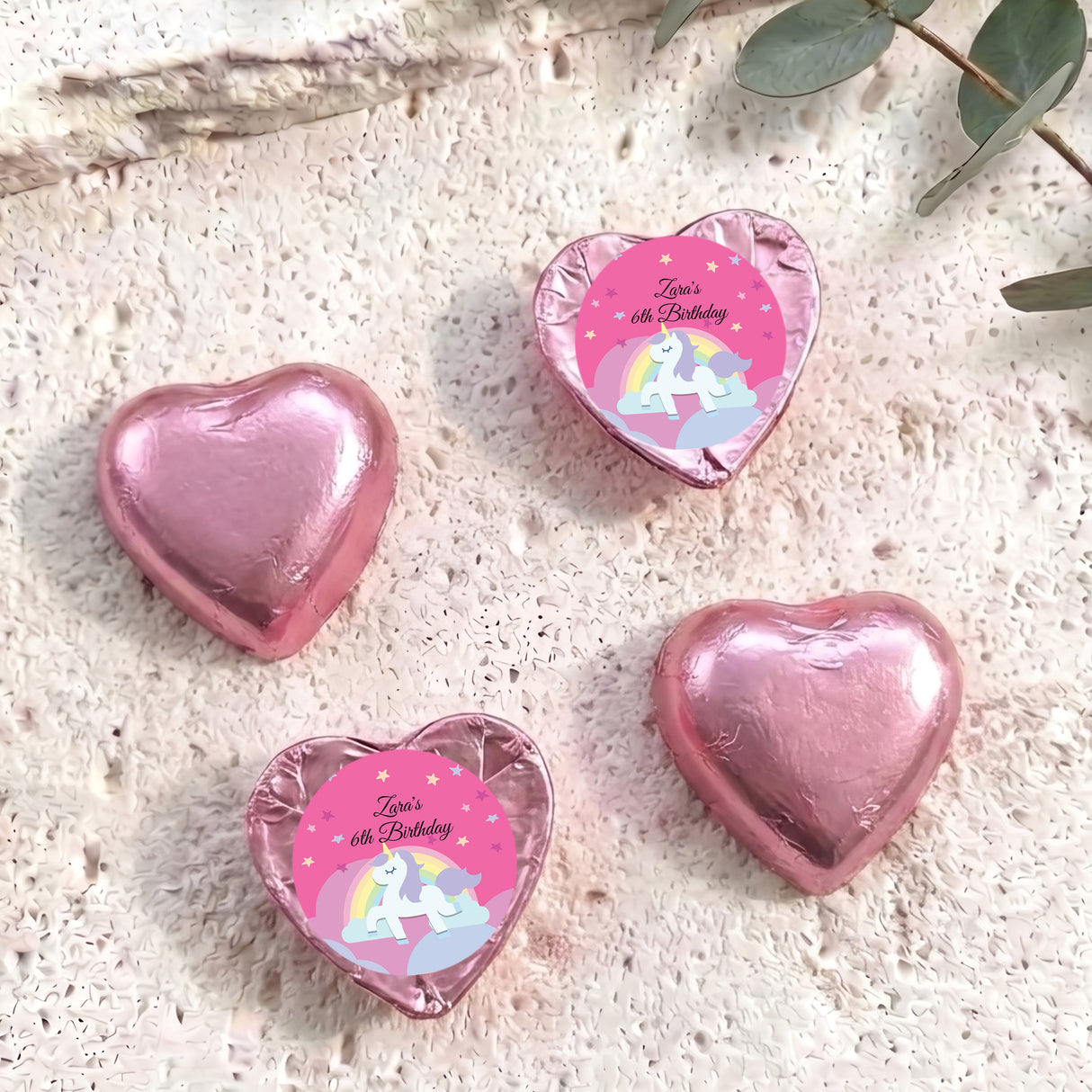 Pink foil chocolate hearts with unicorn label reading “Zara’s 6th Birthday”.