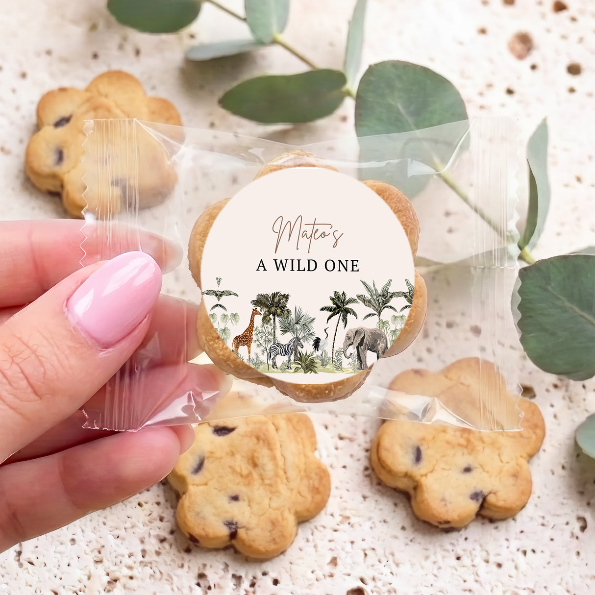 Personalised choc chip cookies with round jungle label, held in hand