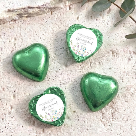 Personalised foil-covered chocolate heart favours in green foil, with printed thank-you labels