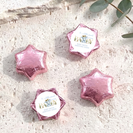 Pink foil-covered chocolate star sweets with baby shower label center