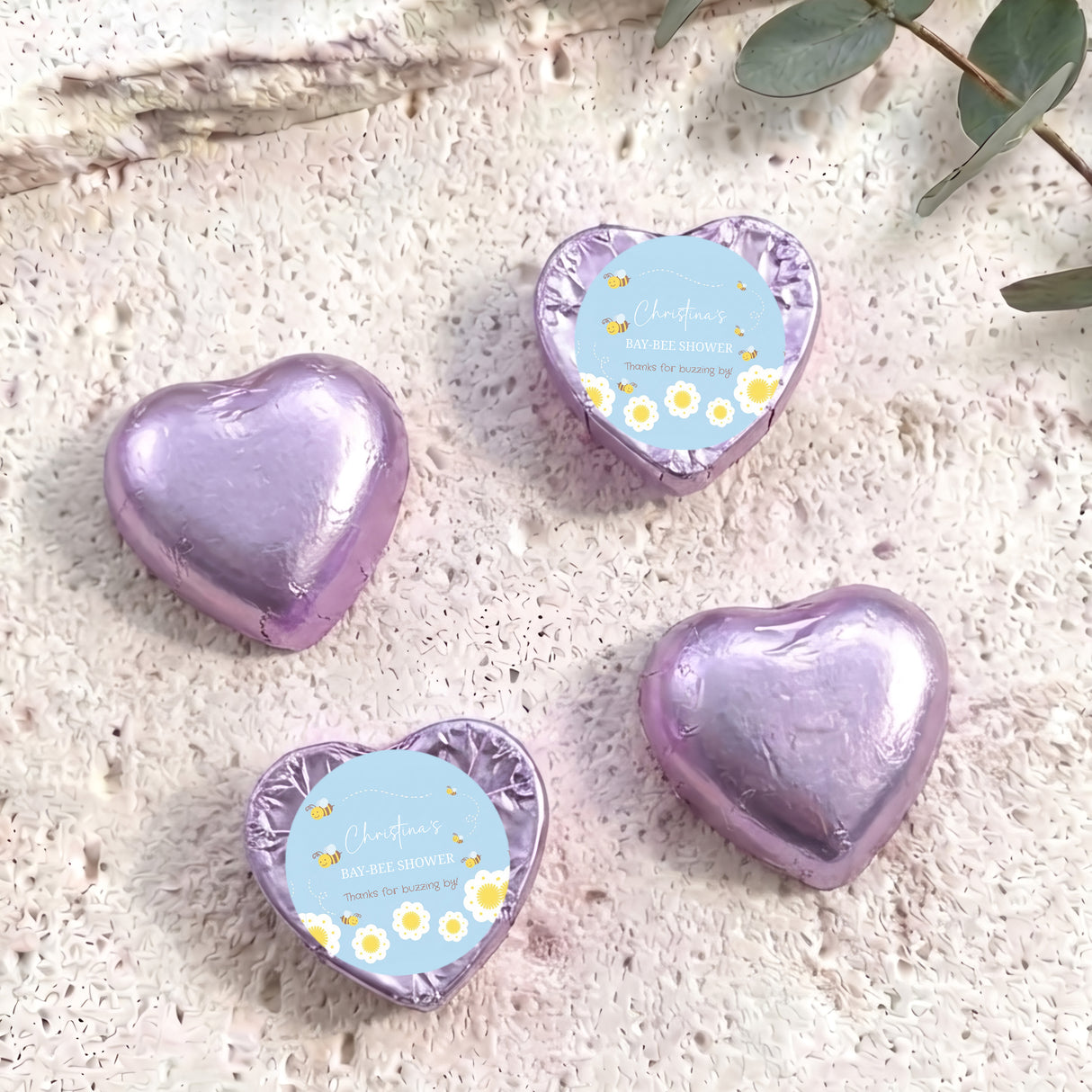Purple foil-covered chocolate hearts with “Baby Bee Shower” gift card labels