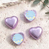 Purple foil-covered chocolate hearts with “Baby Bee Shower” gift card labels