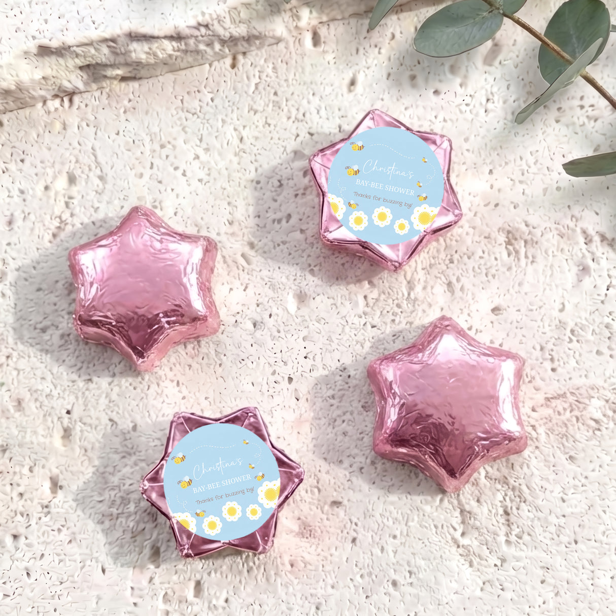 Pink foil-covered star chocolates with personalised baby shower label and floral print
