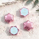 Foil-covered chocolate stars with pink wrappers and white First Communion cross labels.