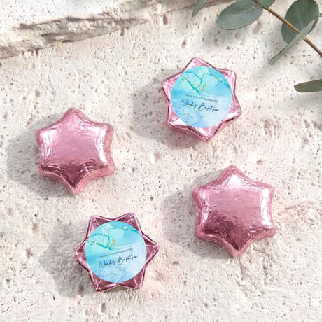 Pink foil-covered chocolate stars with cross and personalized foil wrap