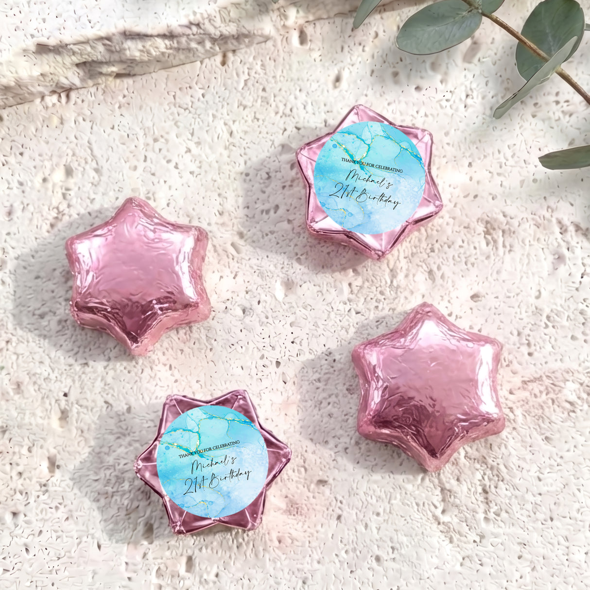 Pink foil-covered chocolate stars with small personalised label