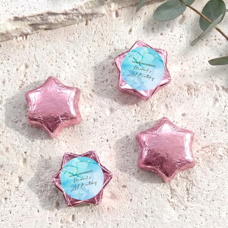 Pink foil-covered chocolate stars with small personalised label