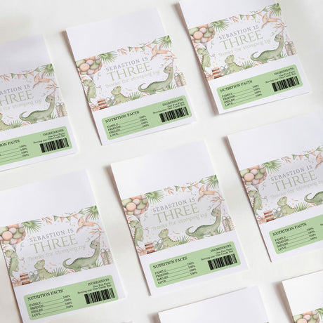 Printed chocolate wrappers, white with green dinosaur and 'Sebastian is Three' text.