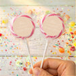 Personalised wedding lollipops with pink swirl tops and beige thank-you labels