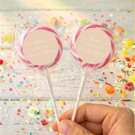 Personalised wedding lollipops with pink swirl tops and beige thank-you labels