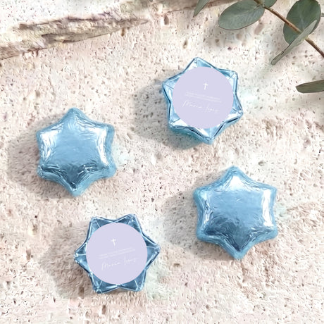 Blue foil-covered chocolate stars with white round labels and a small cross