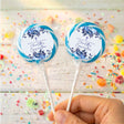 Personalised confirmation lollipops with blue floral labels, transparent wrappers, white sticks