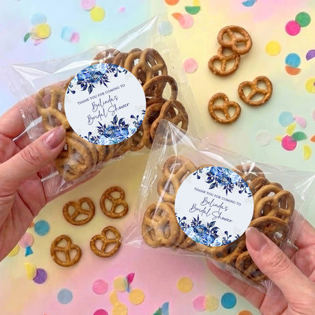 Clear cellophane pretzel bag with blue floral personalized label and pretzels, two-pack