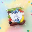 Clear party mix lolly bag with round floral thank-you label on dark contents