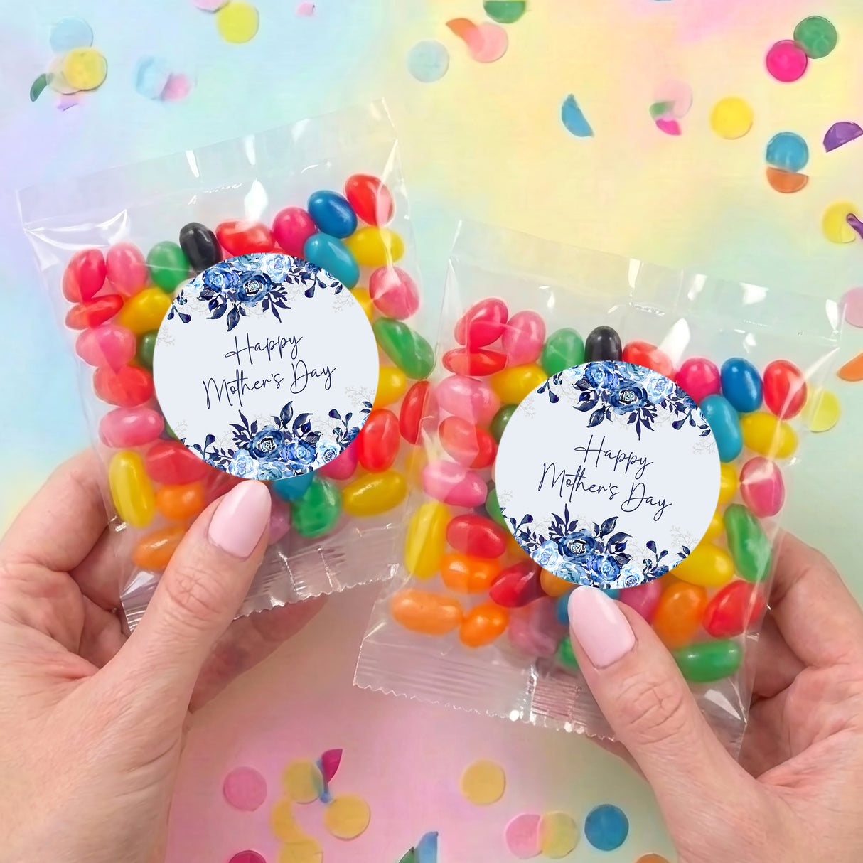 Set of two Happy Mother's Day jelly bean bags with blue floral round labels, held in hands