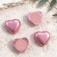 Dusty pink heart-shaped foil-covered chocolates with a round pink label on top