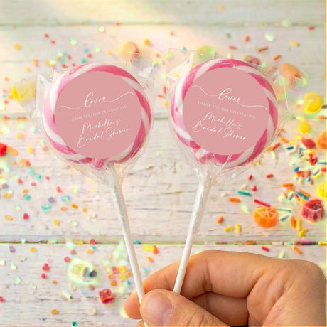 Bridal shower love lollipops: two wrapped candies with dusty pink round labels, pink edges, sticks