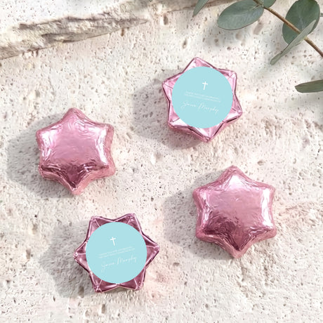 Pink foil-covered chocolate stars with cross medallion labels