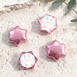 Pink foil covered chocolate star with personalized baby shower card label.