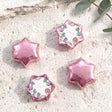 Pink foil star balloons plus pink dinosaur “Dolly is Four” foil balloon