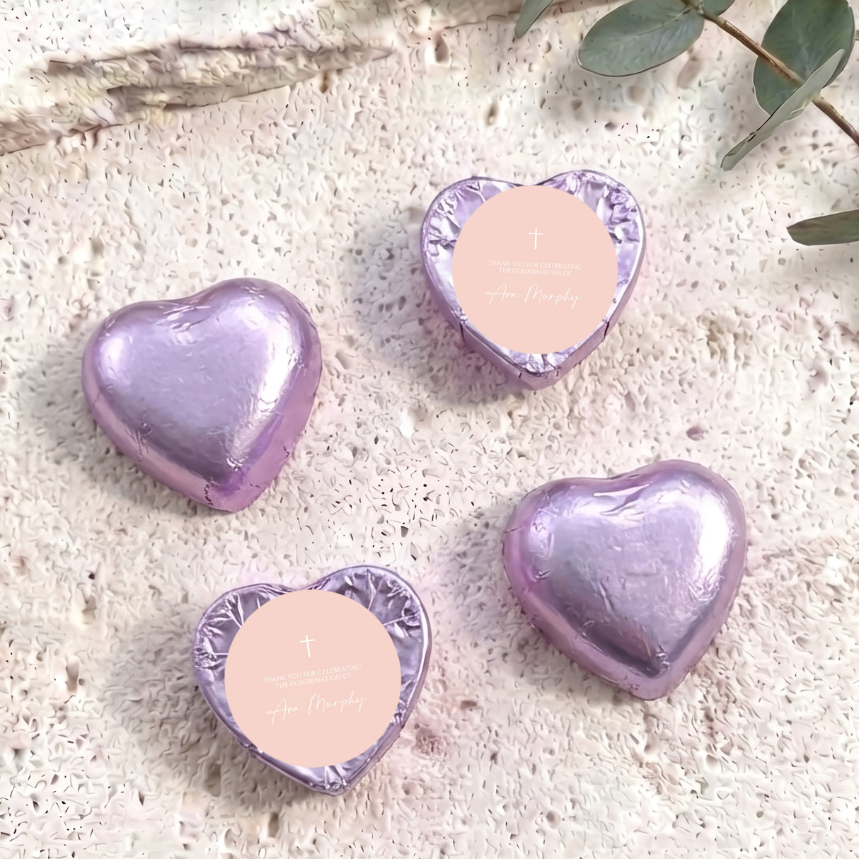 Foil-covered chocolate hearts in pastel purple with cross and personal message