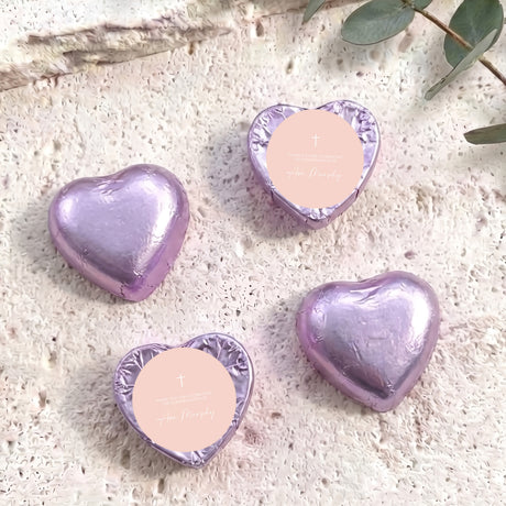 Foil-covered chocolate hearts in pastel purple with cross and personal message