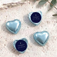 Foil-covered chocolate hearts, blue metallic with navy label and cross
