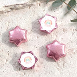 Foil-covered chocolate stars in pastel pink and purple with white center label.