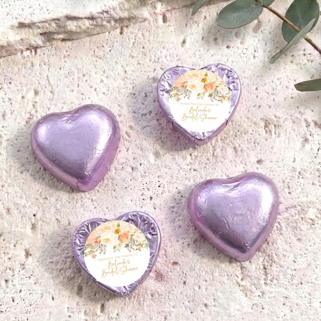 Foil heart chocolates with floral label, four lavender heart sweets arranged.