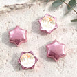 Foil-covered star chocolates with pink foil and a white floral name label