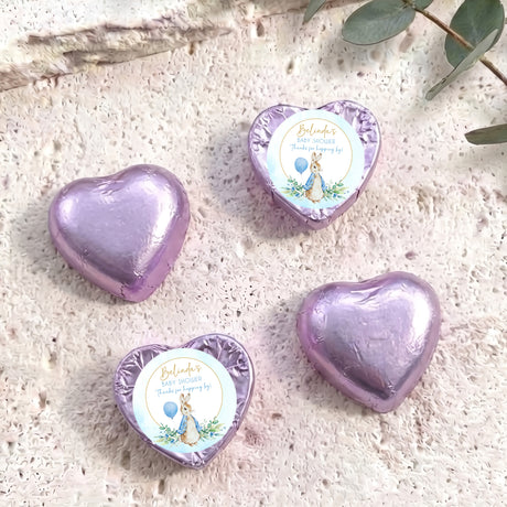 Purple foil-covered chocolate heart with baby shower label and blue bunny illustration