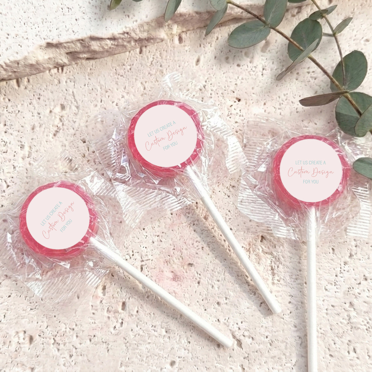 Mini lollipops with red lollipop tops, wrapped in clear plastic on white sticks.