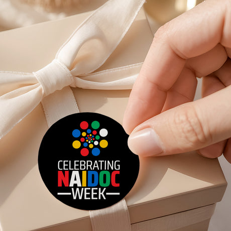 Round celebrating Naidoc Week printed label with multicolor dots on white ribbon