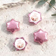 Pink foil-covered chocolate stars with round 'Baby Shower' label