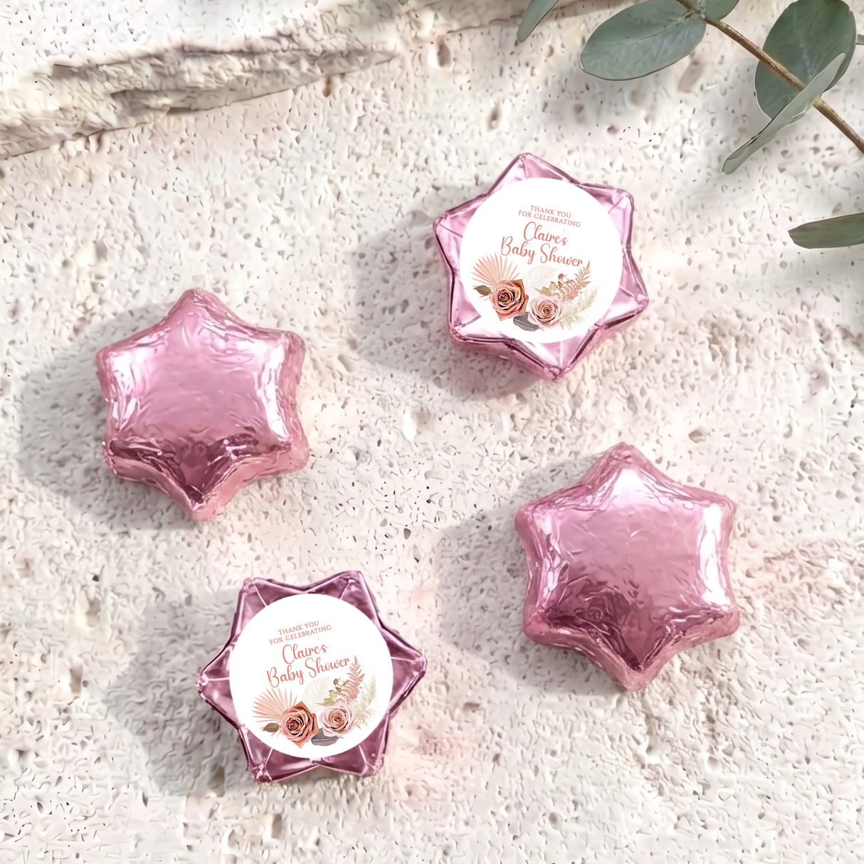 Pink foil-covered chocolate stars with round 'Baby Shower' label