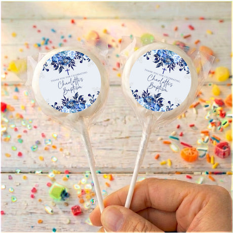 Personalised lollipops with blue floral labels in clear wrappers, held by stick ends.