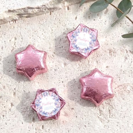 Pink foil-covered chocolate stars with floral First Holy Communion label