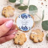 Personalised bite-size cookies in clear bag, blue floral baptism label held by hand