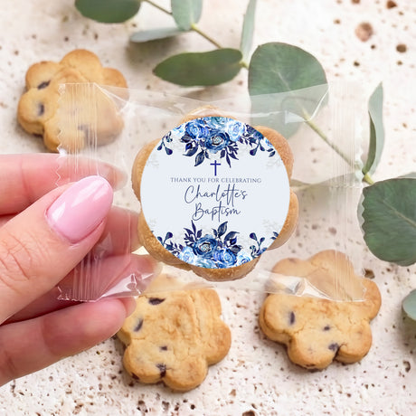 Personalised bite-size cookies in clear bag, blue floral baptism label held by hand