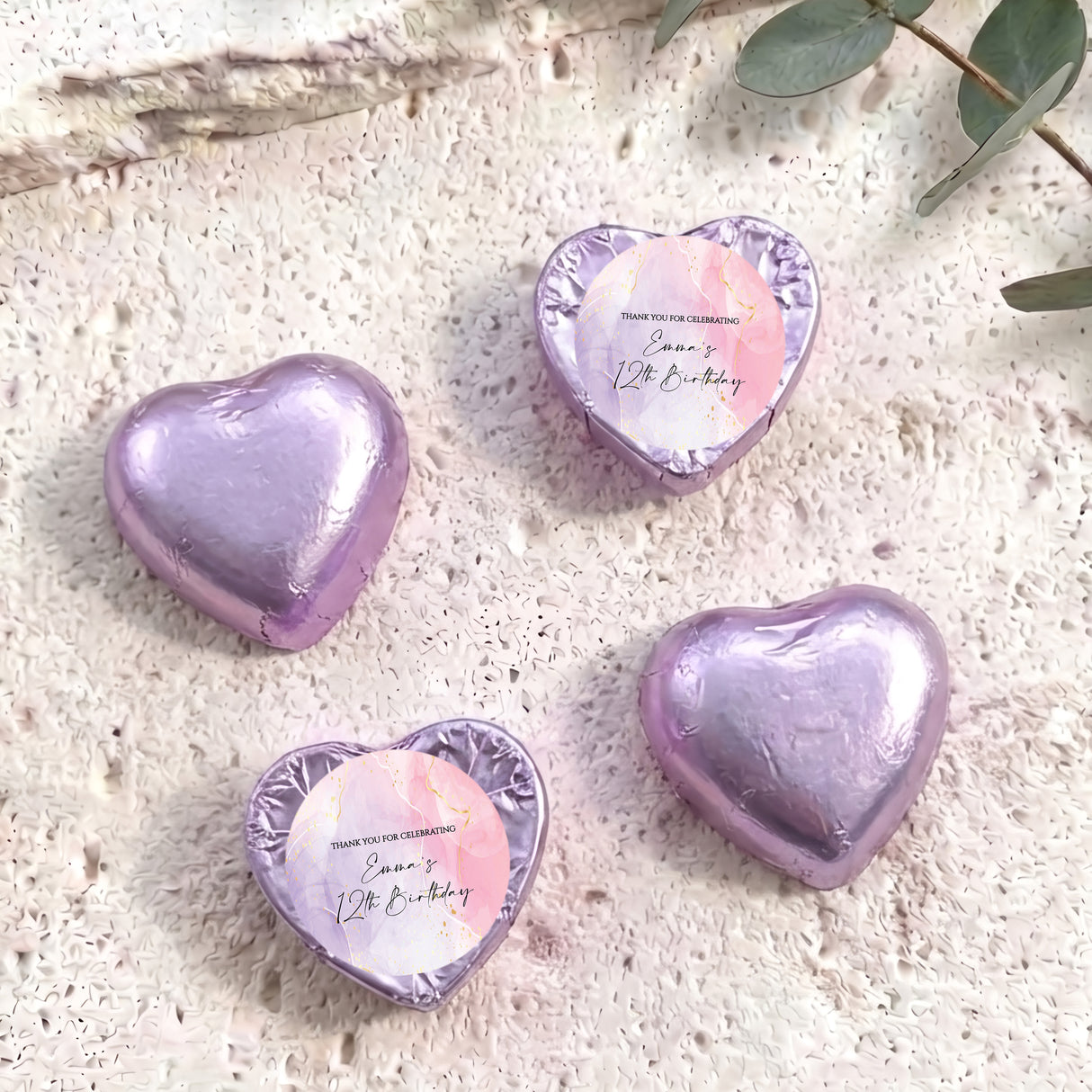 Purple foil-covered heart chocolates with a round personalised label on top
