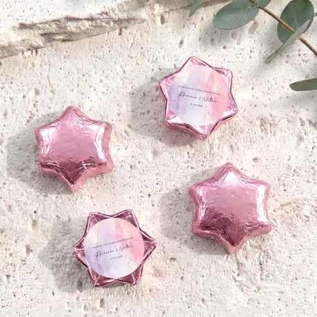Pink foil star chocolates with circular personalized label inside star-shaped wrap